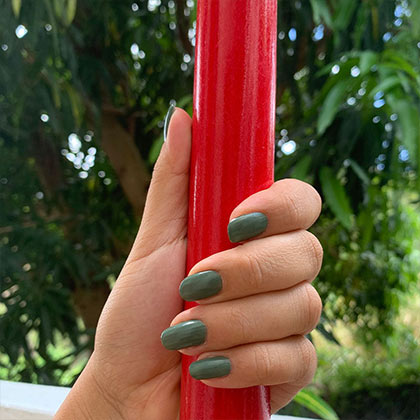 hand on red pole wearing naupaka breathable nail polish