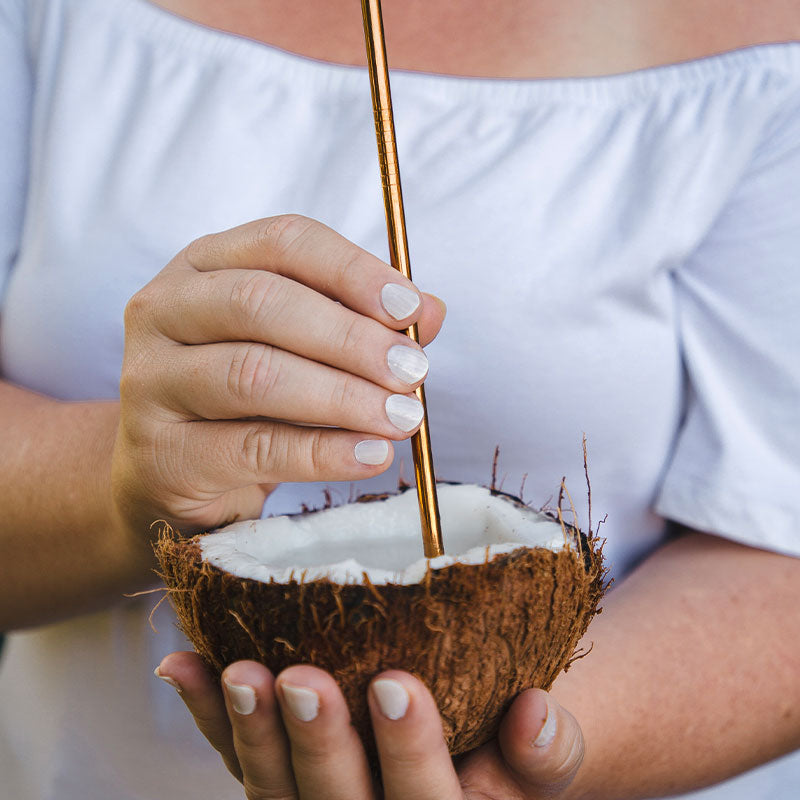 women holding coconut wearing coconut non toxic nail polish
