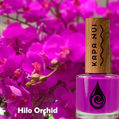 hilo orchid breathable nail polish bottle next to purple orchid flower