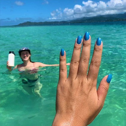 women with painted nails with kailua bay non toxic nail polish in the ocean at kailua bay