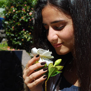 wahine holding white flower nails painted with kalapana non toxic nail polish