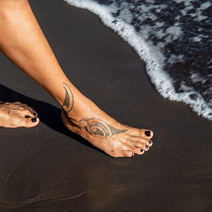 wahine wearing kalapana non toxic nail polish on her toes at a black sand beach