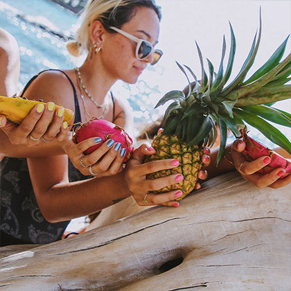 women holding fruit wearing kapa nui nails non toxic nail polish