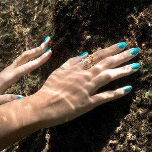hands underwater with nails polished with molokini mermaid non toxic nail polish