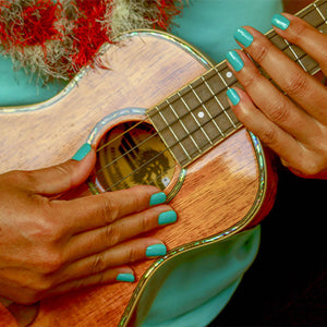 woman playing ukulele wearing non toxic nail polish in color nalu