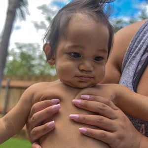 mom holding baby wearing pua  melia non toxic nail polish