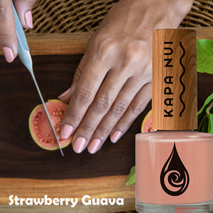 strawberry guava non toxic nail polish bottle next to woman cutting strawberry guava 