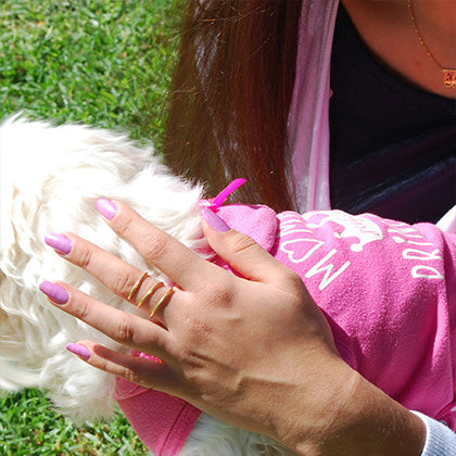 sweet wahine wearing sweet wahine non toxic nail polish holding her white dog
